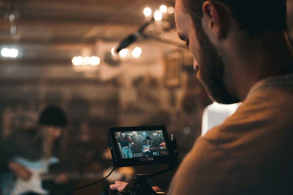Filmmaker capturing a live music performance indoors on set. Perfect for videography themes.